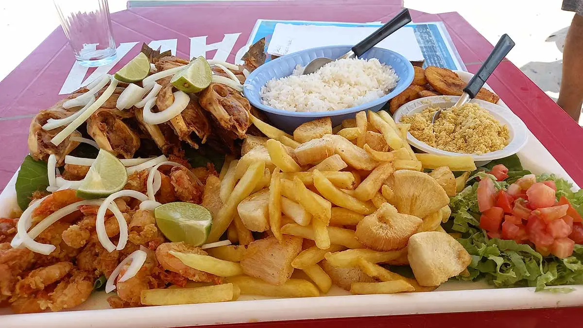 Mesa com petiscos e frutos do mar à beira da praia em Piúma Espírito Santo